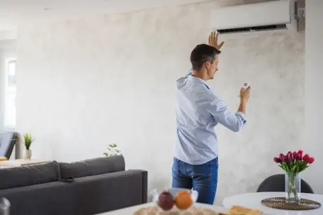 man adjusting the AC temperature