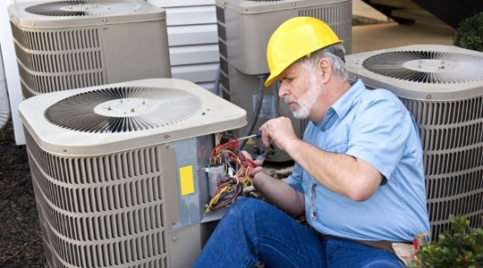 tech works on an AC unit